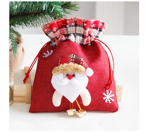 Close-up of burlap Christmas gift bag with 3D Santa plush and gold bells decor
