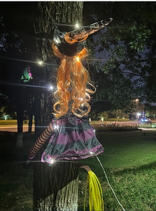 Close-up of glowing Halloween tree-crashing witch with LED lights and orange hair