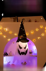 Dettaglio del fantasma di Halloween appeso con cappello da strega e luci LED calde