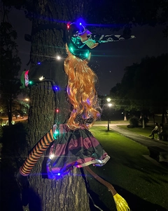 Detail of outdoor Halloween tree-hugging witch with colorful LED lights and striped socks