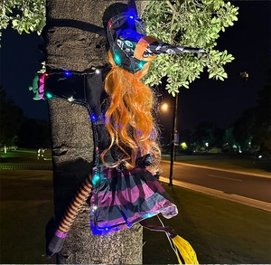 Detail of LED light-up tree-climbing witch with purple skirt for Halloween garden decor