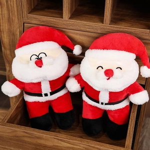 Detailed view of two plush Santa Claus dolls with festive expressions in a wooden drawer
