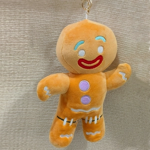 Cute gingerbread man plush keychain with embroidery on beige knitted background