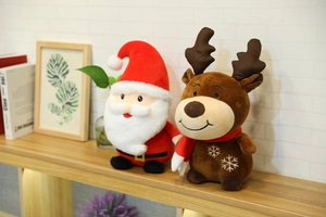 Close-up of plush Santa and reindeer Christmas dolls with snowflake embroidery details
