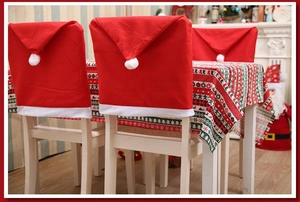 Close-up of festive Christmas chair covers with Santa hats and themed tablecloth set