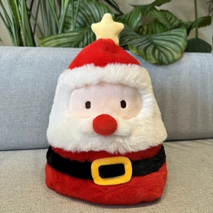 Detail of plush Santa Claus figure with yellow star and black belt on soft sofa