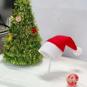 Mini red velvet Christmas hats and striped candy toppers on sticks for festive decoration