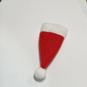 Close-up of mini non-woven red Christmas hat with white plush pompom for lollipop decor