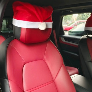 Close-up of a plush red Christmas hat car headrest cover on a red leather car seat