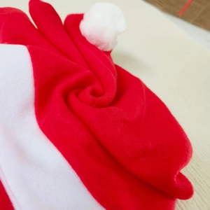 Close-up of soft red plush fabric and white faux fur trim on a Christmas car headrest cover