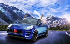 Action shot of brown reindeer antlers and red nose kit on a blue SUV in the snowy mountains