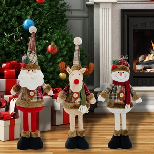 Drie kerstfiguren van de Kerstman, Rendier en Sneeuwpop op een gezellige haard achtergrond