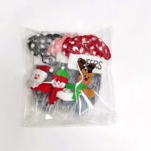 Trois décorations de Noël en peluche avec Père Noël et renne sous emballage clair