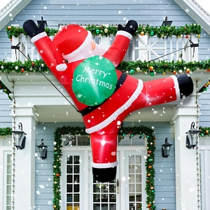 Detail of inflatable Santa climbing wall with green gift bag and Merry Christmas text
