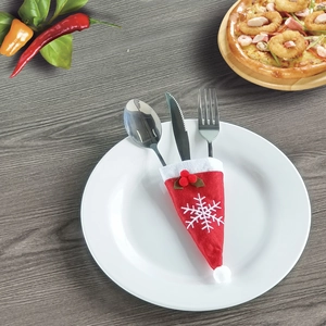 Christmas Santa hat cutlery holder with snowflake embroidery on a white dinner plate