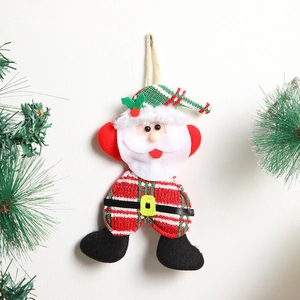 Close-up of handmade fabric Santa ornament with knitted textures and pine branch decor