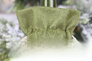 Dettaglio del copribottiglia in tela di iuta verde con coulisse bianca e texture