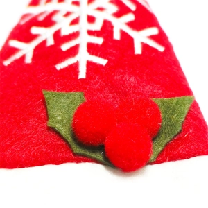 Macro view of Christmas red felt cutlery holder with white snowflake and 3D berry details