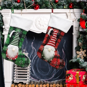 Set of two festive gnome Christmas stockings with plaid patterns on a cozy white fireplace