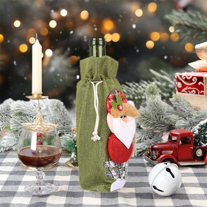 Dettaglio copribottiglia natalizio in juta verde con decorazione pupazzo di Babbo Natale 3D