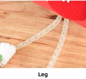 Détail de jambes de peluche de Noël avec tissage doré et flocon sur feutre rouge