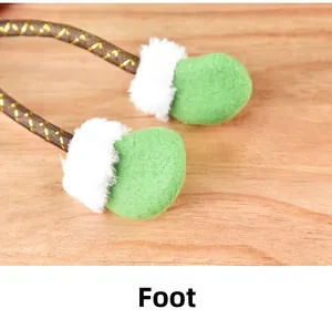 Détail de jambes de décoration de Noël en peluche verte avec bordure blanche et fil d'or