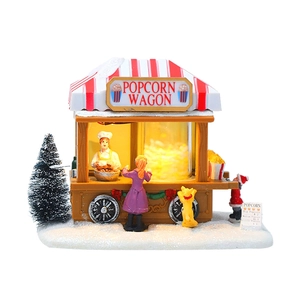 Dettagliato carretto di popcorn natalizio con luci calde e statuine in resina innevata