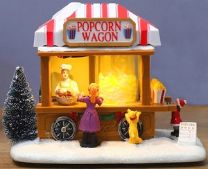 Dettaglio del carro di popcorn natalizio luminoso con figurine e base innevata decor
