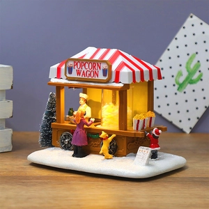 Dettaglio del carro di popcorn natalizio illuminato con figurine e neve artificiale