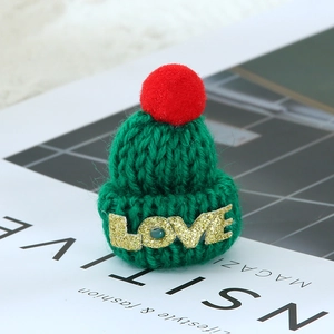 Mini green knit Christmas hat with red pom-pom and golden glitter LOVE lettering