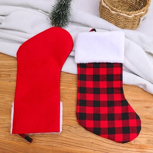 Détail de chaussettes de Noël en peluche rouge et à carreaux avec fausse fourrure
