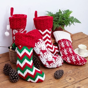 Set of four knitted Christmas stockings with festive patterns on a cozy wooden background