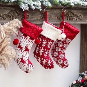 Detailed knit texture of red and white Christmas stockings with elk and snowflake patterns