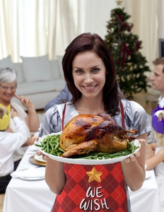 Red plaid Christmas apron with gold star and We Wish text shown in festive dining scene