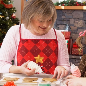Detail of a red plaid Christmas apron and baking squeeze bottles in a festive kitchen