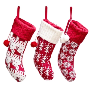 Three-piece knitted Christmas stocking set with reindeer, snowflake, and tree patterns