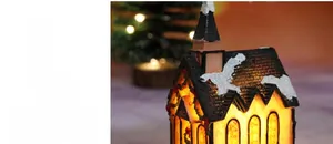Gros plan d'une église de Noël en résine lumineuse avec texture de neige et lumières LED
