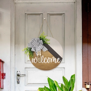 Détail de plaque welcome en bois avec feuilles d'eucalyptus et nœud à carreaux
