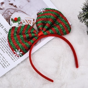 Detail eines rot-grün gestreiften Weihnachts-Haarreifs mit großer Glitzerschleife und Flocke