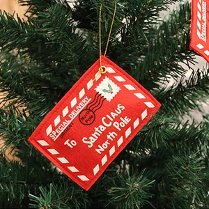 Red felt Christmas envelope ornament with gold string hanging on a green Xmas tree