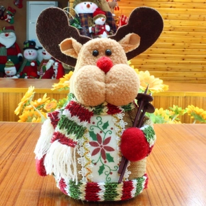 Detail of plush Christmas reindeer toy with striped scarf and mini wooden ski stick