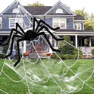 Giant black plush spider with red eyes on large white spider web for Halloween yard decor