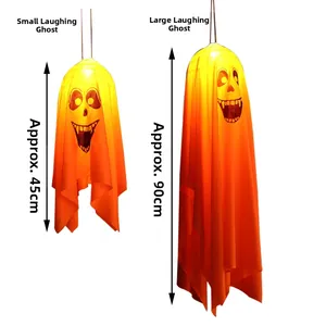 Detail of hanging Halloween ghosts in two sizes with orange gradient and laughing face