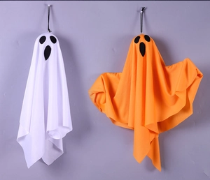 Close-up of white and orange hanging ghosts for Halloween with spooky faces and ropes