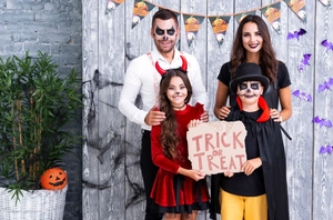 Famille portant des costumes de diable rouge et noir pour Halloween dans un décor festif