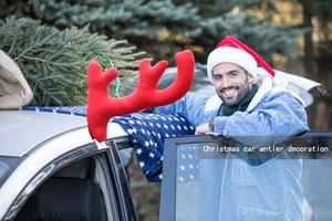 Detail of red plush reindeer antlers for car window decoration in a festive outdoor scene