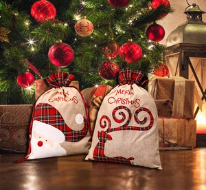 Detailed view of burlap Christmas drawstring gift bags with Santa and Reindeer designs