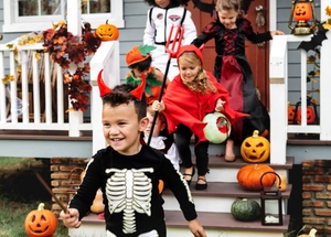 Scène extérieure d'enfants en costumes d'Halloween, cape de diable, crâne et citrouille