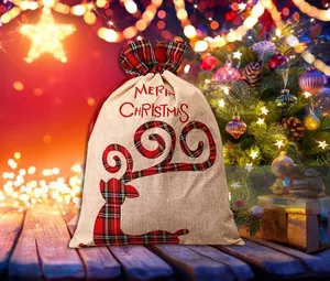 Detail of burlap Christmas gift bag with tartan trim and Merry Christmas print