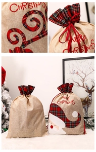 Detail of Christmas burlap gift bag with red embroidery, plaid trim and ribbon closure